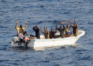 Suspected pirates keep their hands in the air before being arrested in the Gulf of Aden