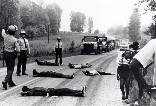 Afton protesters lie in the street, blocking dumptrucks of contaminated soil. Photo from http://www.citylab.com/politics/2015/11/how-the-collapse-of-soul-city-fired-up-the-environmental-justice-movement/415530/